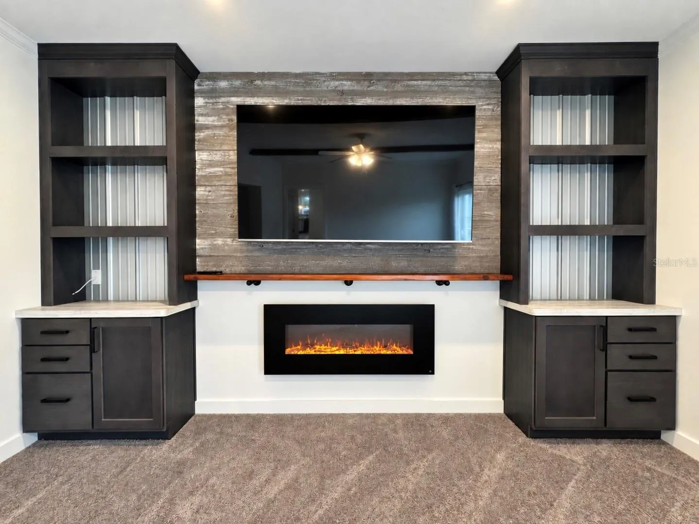 Fireplace in family room with wall-mounted tv ad built-in shelves.