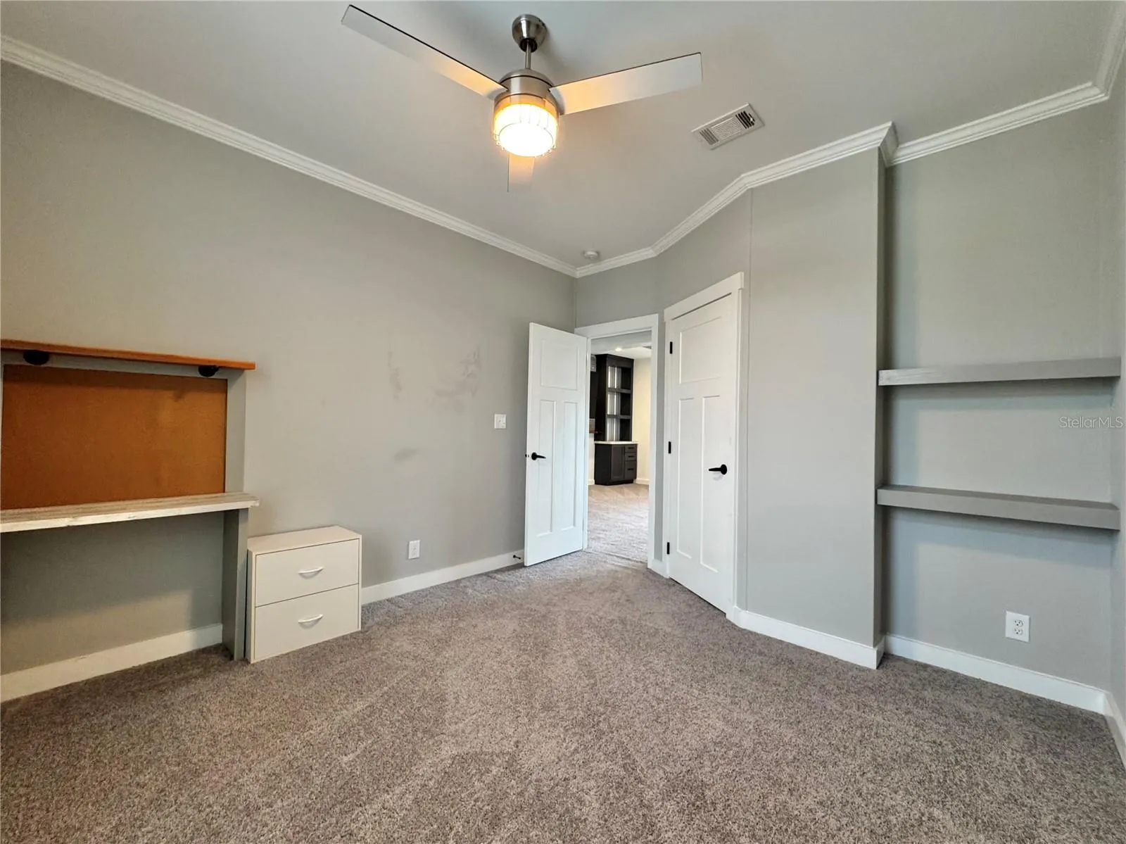 Bedroom 2 with built-in shelves and walk-in closet.
