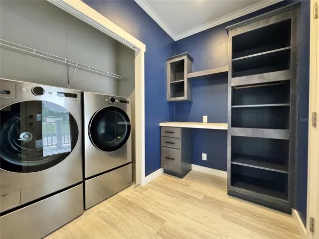 Laundry room with built-in desk and shelves.