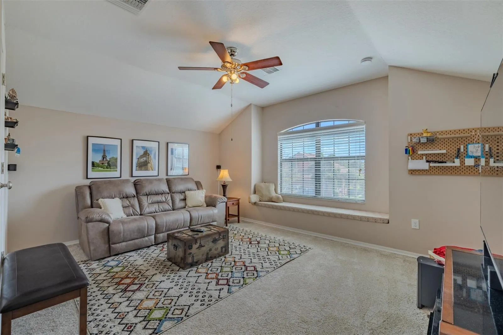 Awesome bonus room with lovely window seat.Bonus room sofa and TV stand convey.