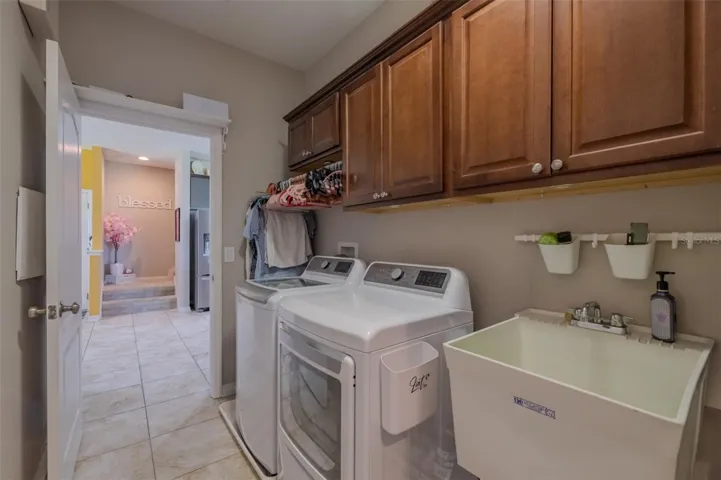 Laundry room conviently located with a wash sink and cabinets. Washer & dryer do not convey