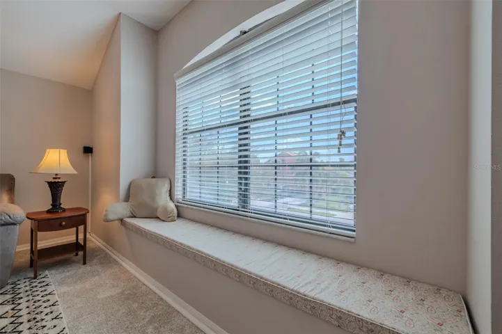 Awesome bonus room with a lovely window seat. Bonus room sofa and TV stand convey.