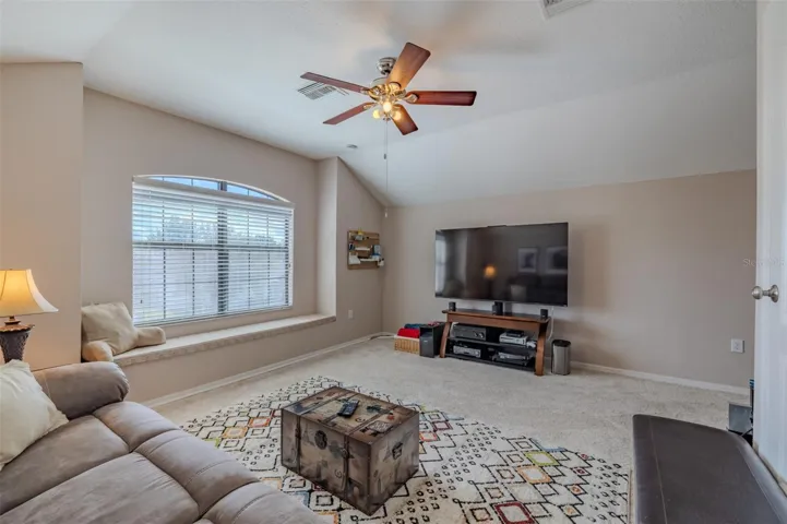 Awesome bonus room with lovely window seat. Bonus room sofa and TV stand convey.