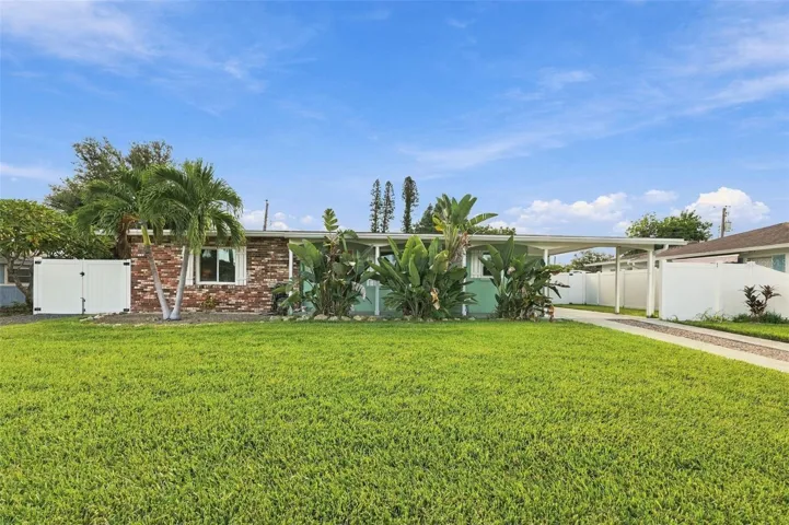 Front view. (Right side of home has driveway leading to carport. Left side has shell driveway leading to double gated fenced in area. )