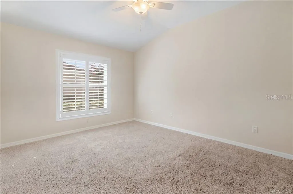 BEDROOM 3 – Spacious bedroom featuring ceiling fan &amp; window with plantation shutters.
