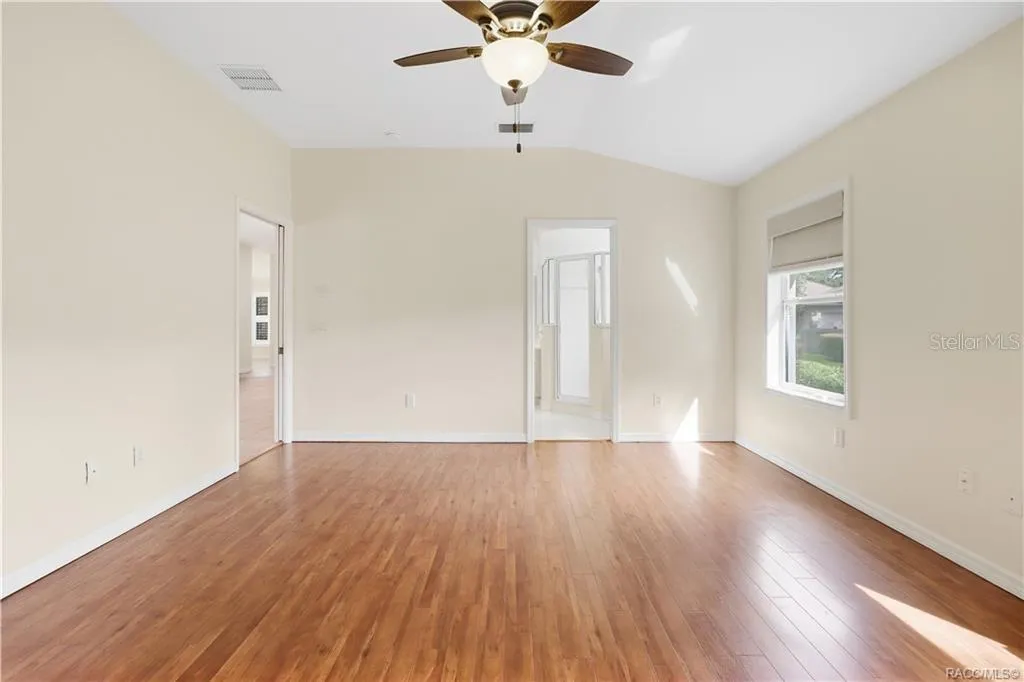 PRIMARY BEDROOM – Alternate view of the primary suite highlighting the LUXURY VINYL PLANK FLOORING &amp; direct access to the adjoining primary bathroom. LIGHT &amp; BRIGHT