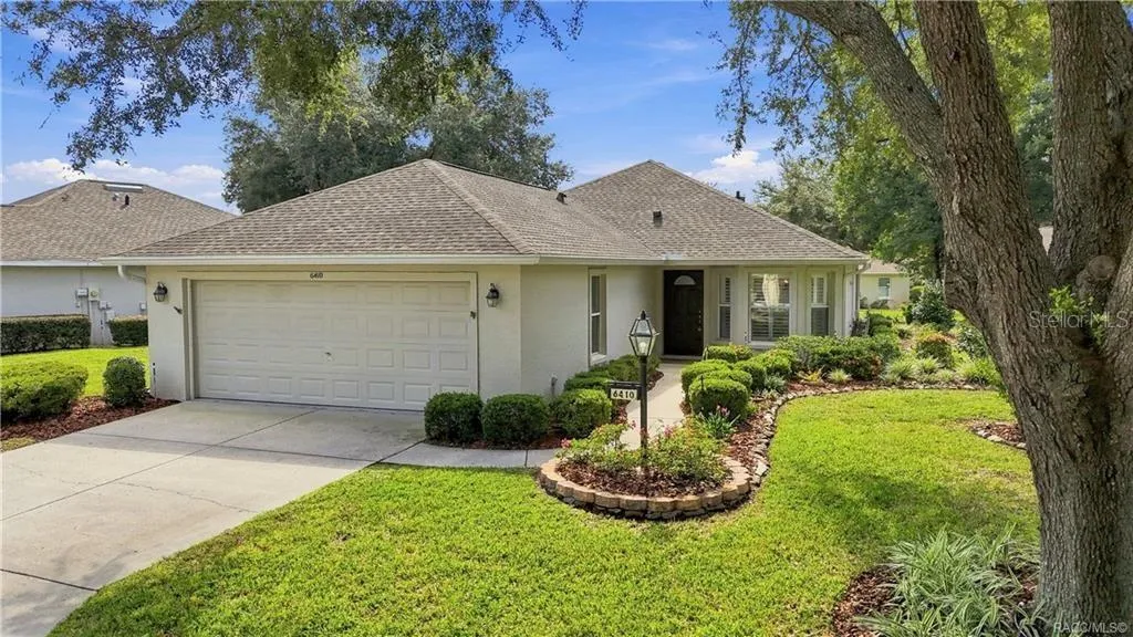 FRONT EXTERIOR – Attractive front elevation framed by mature shade trees, manicured landscaping &amp; a curved walkway leading to the covered entry, plus an attached 2-car garage.