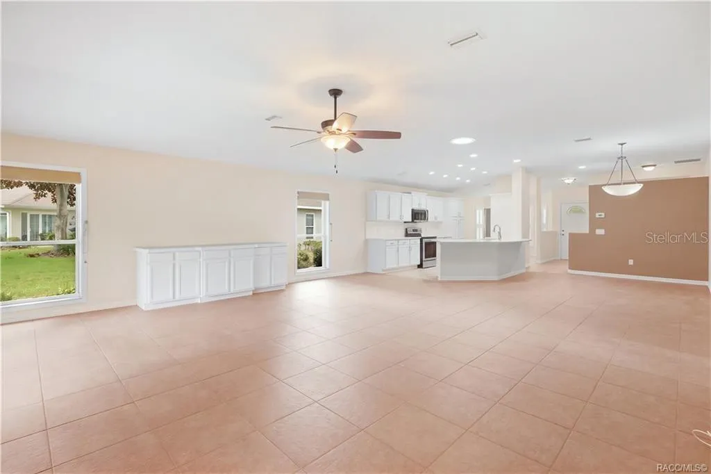 OPEN-CONCEPT LIVING – Wide-angle view showing just how open the living area feels, with the kitchen, dining space &amp; great room visually connected. Built-in cabinetry provides additional storage while large windows add natural light.