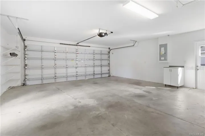 2-CAR GARAGE – Spacious attached garage with automatic garage-door opener, overhead lighting, concrete flooring, wall shelving &amp; additional storage cabinet.