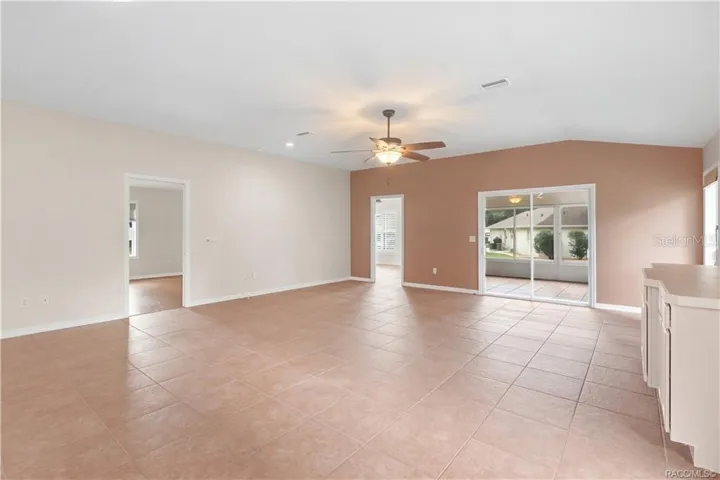 Living Room / FLORIDA ROOM VIEW – Another angle showcases the width of the main living space and its easy connection to adjoining rooms. Sliding glass doors bring in additional natural light while providing direct access to the Florida room.