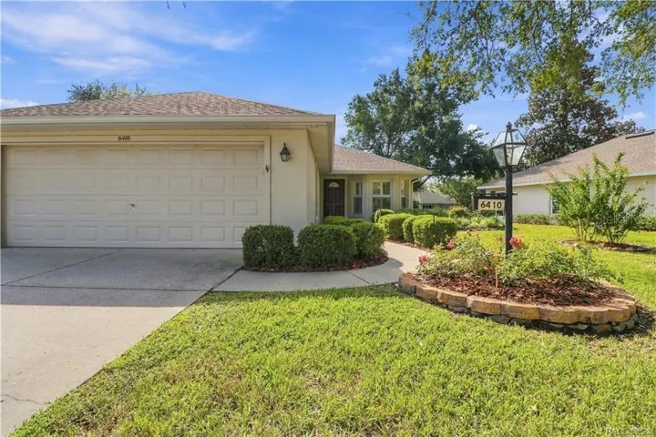 FRONT EXTERIOR – Inviting curb appeal with a manicured lawn, established landscaping, colorful planting beds, covered entry &amp; attached 2-car garage. The front bay-style windows add architectural interest while bringing natural light inside.