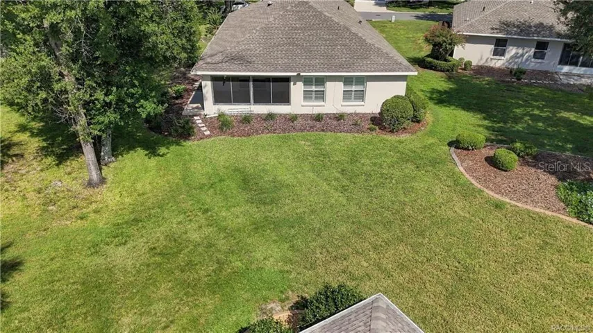 BACKYARD – Elevated view highlighting the spacious open backyard (common area), established trees, landscaped beds &amp; rear exterior of the home.
