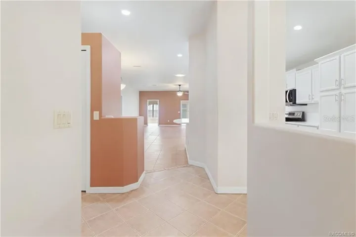 OPEN INTERIOR VIEW – From the front of the home, the floor plan opens toward the main living area &amp; kitchen, creating an easy connection between spaces. Tile flooring, recessed lighting &amp; interior architectural openings enhance the spacious feel.