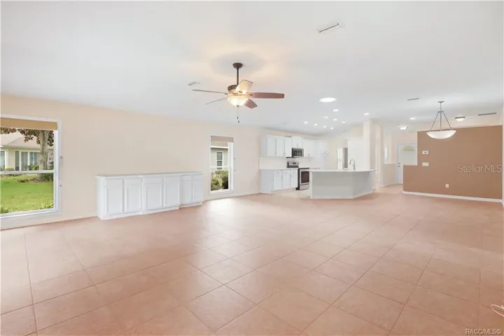 OPEN-CONCEPT LIVING – Wide-angle view showing just how open the living area feels, with the kitchen, dining space &amp; great room visually connected. Built-in cabinetry provides additional storage while large windows add natural light.