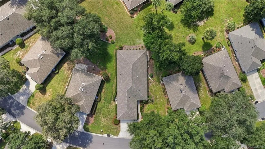 AERIAL PROPERTY VIEW – Overhead aerial showcasing the home’s placement within the neighborhood, driveway, mature trees, surrounding green space &amp; neighboring properties.