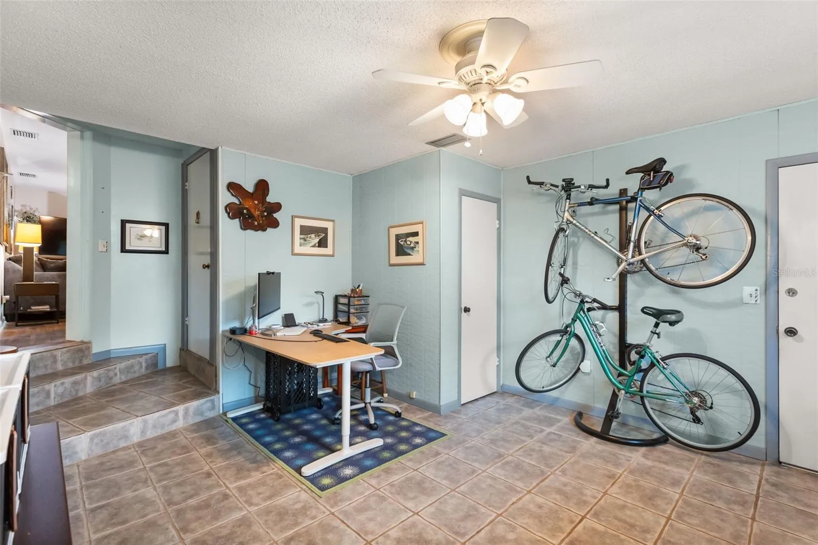 One of the downstairs bonus rooms has a storage closet (by bicycles).  The door to the left leads upstairs.  The door to the right leads to the garage.  Living room is seen in the far left.