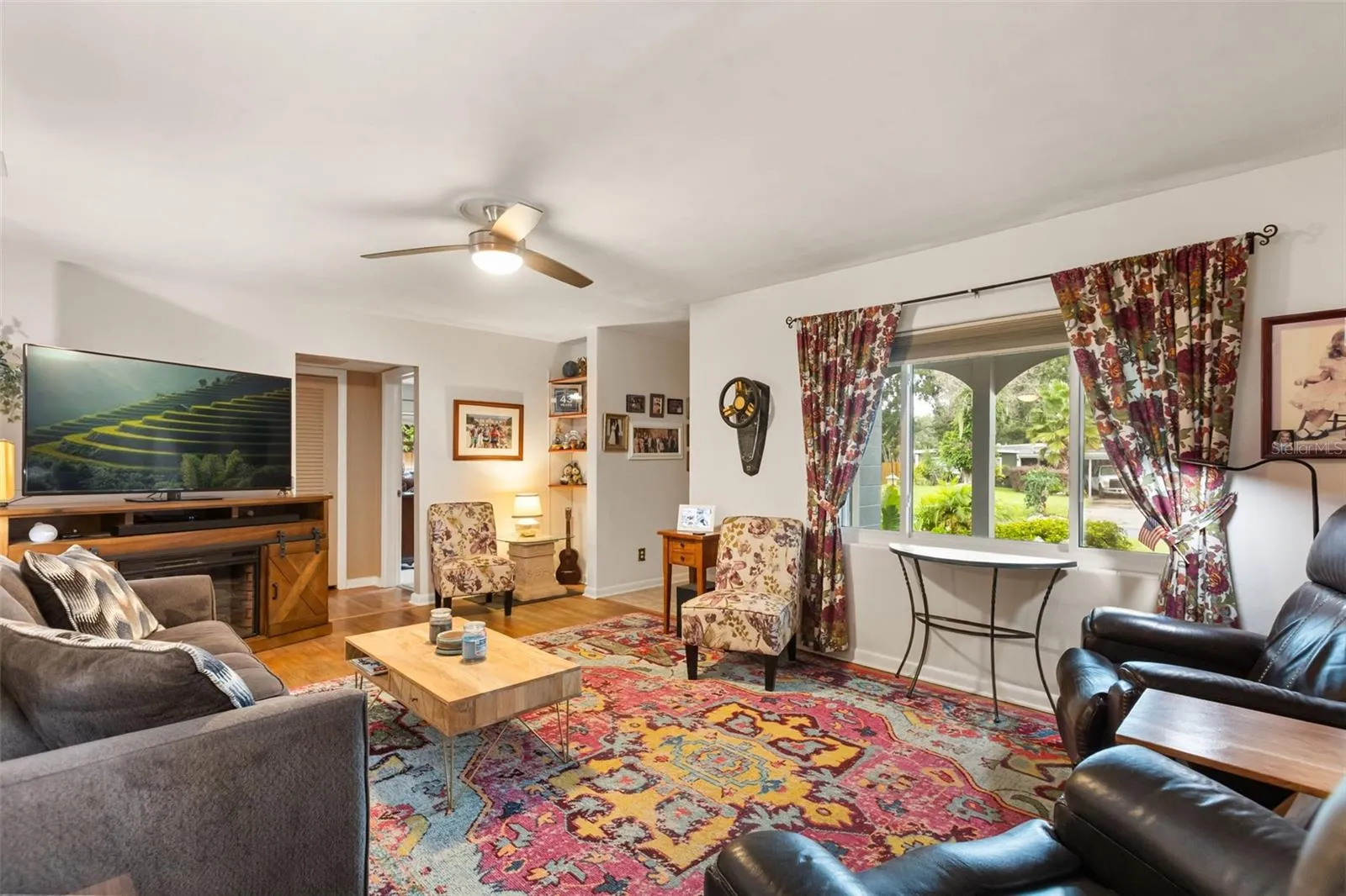 Living room.  Front door is to the far right.  Hallway leads to primary bedroom on right, guest bathroom, and bedrooms 2 and 3 are to the left.