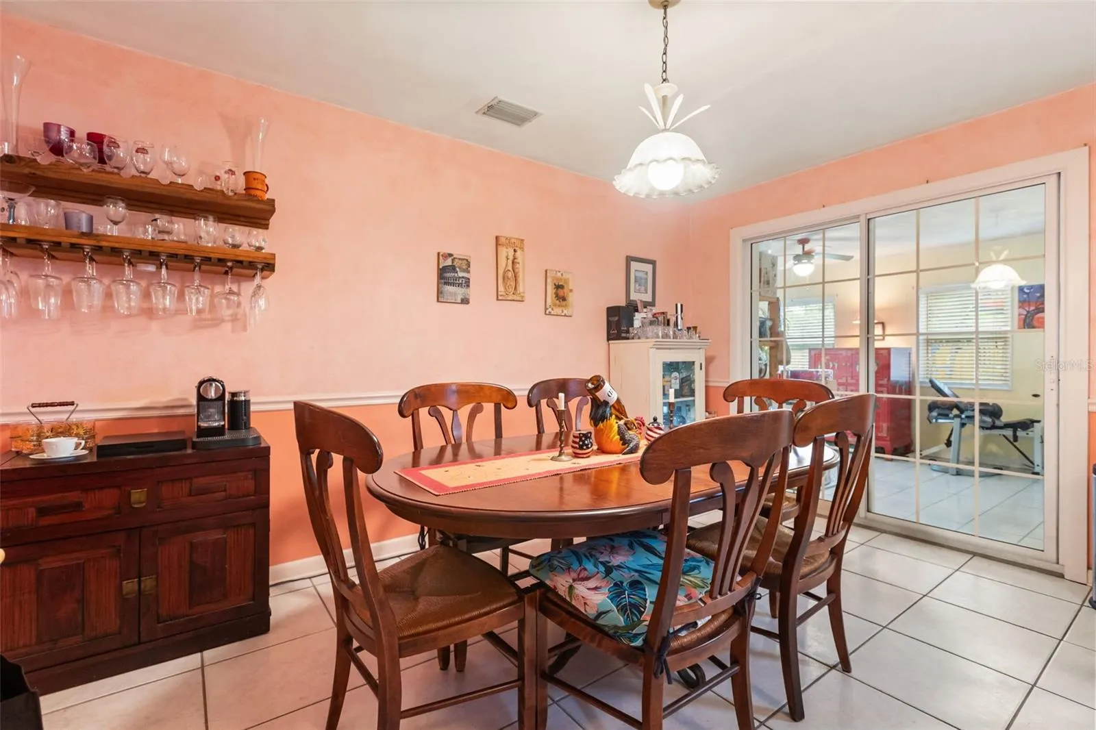 Dining room with one of the air conditioned bonus rooms through sliding glass doors.