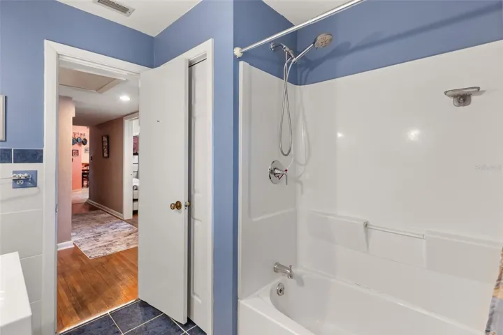 First floor guest bathroom with linen closet.  Primary bedroom is down hallway to the left.  Bedrooms 2 and 3 are to the right.  Kitchen is straight ahead.