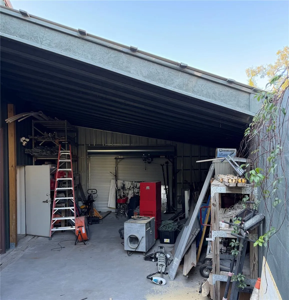 Over 250 SF of additional exterior covered work space-with breezeway roll up door in the back of area