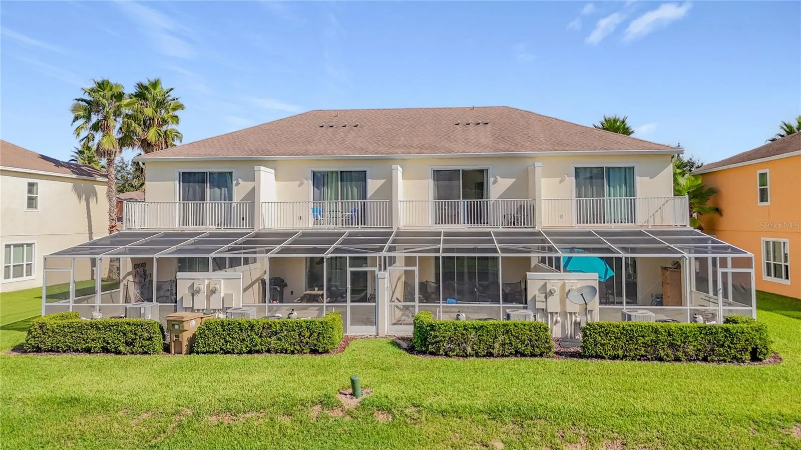 Rear Exterior — Rear view showcases the home's private pool enclosure, upstairs balcony, and desirable open setting overlooking the pond area.