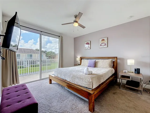 Primary Suite — Large sliding glass doors fill the primary bedroom with natural light and open directly to the private balcony overlooking the pond.