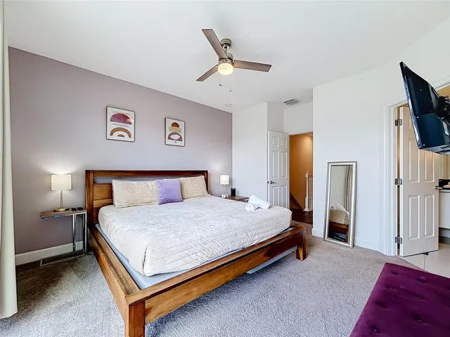 Primary Suite — Spacious upstairs primary suite with king-size bed, private bath, and direct access to the balcony.
