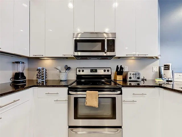 Kitchen — Sleek stainless steel appliances complement the bright cabinetry and contemporary finishes.