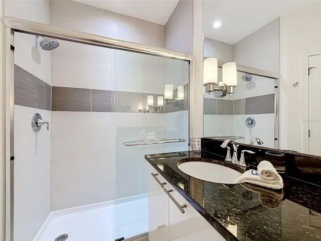 Primary Bathroom — Primary en-suite features a spacious walk-in shower with glass enclosure.