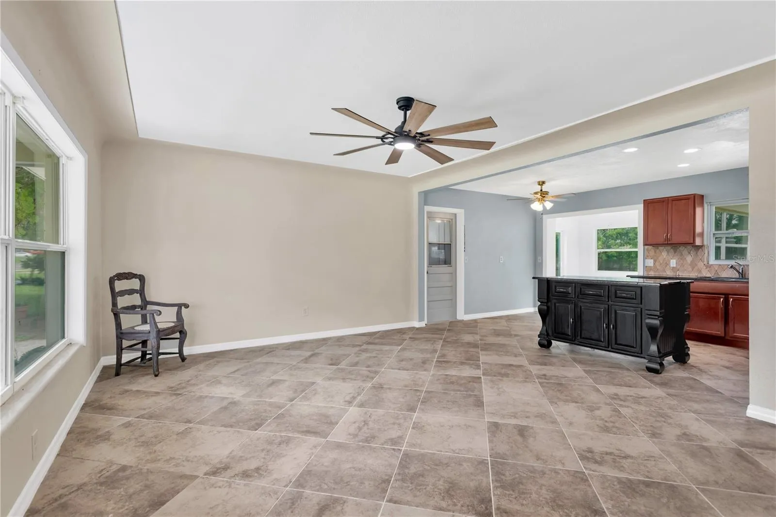 The spacious living room flows seamlessly into the kitchen and features decorative ceiling detailing with a raised border that adds architectural character and visual interest.