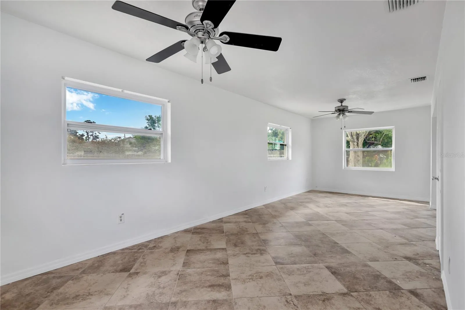 The spacious Primary Bedroom features plenty of windows for natural light, ample room for furnishings, and a beautifully remodeled ensuite bath.
