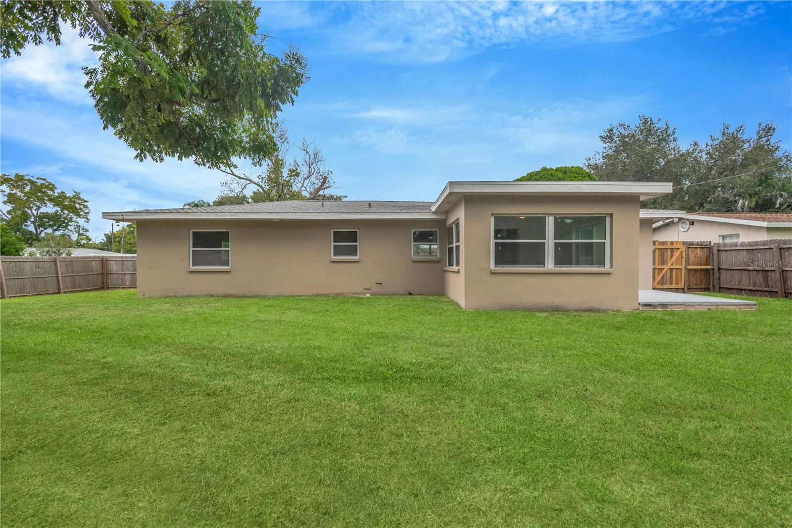 View of back of home and fully fenced yard.