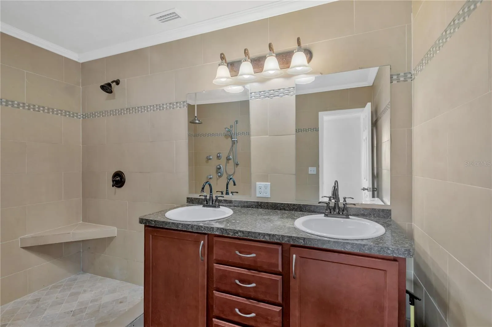 The primary ensuite has been 100% renovated and has dual sinks, a large walk-in shower with built-in seating, crown molding and designer tile installed floor to ceiling.