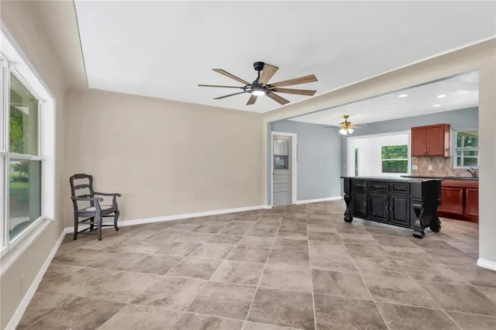 The spacious living room flows seamlessly into the kitchen and features decorative ceiling detailing with a raised border that adds architectural character and visual interest.