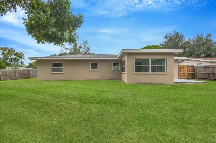 View of back of home and fully fenced yard.