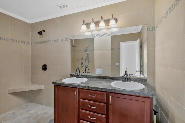 The primary ensuite has been 100% renovated and has dual sinks, a large walk-in shower with built-in seating, crown molding and designer tile installed floor to ceiling.