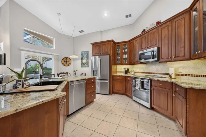 Gorgeous Remodeled Kitchen with Granite and Newer Stainless Steel appliances, Stone backsplash.