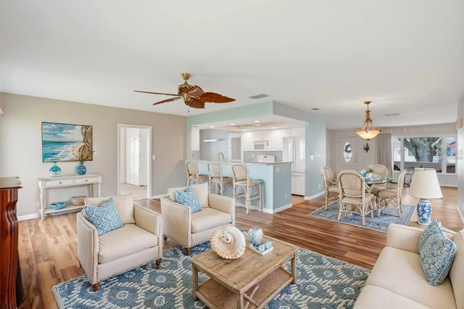 Virtually staged family room with bar stools at the kitchen counter.