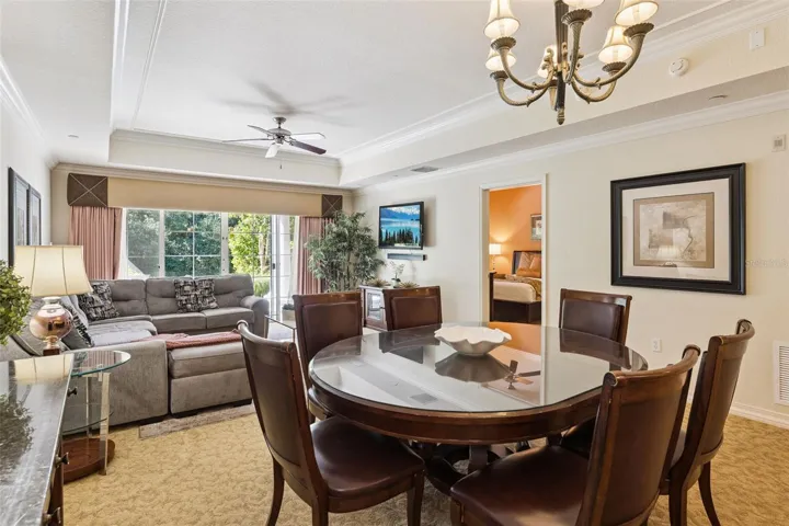 Dining Area: Dedicated dining space featuring an overhead chandelier, tray ceiling detailing, and an easy flow into the adjacent living room and bedroom hall.