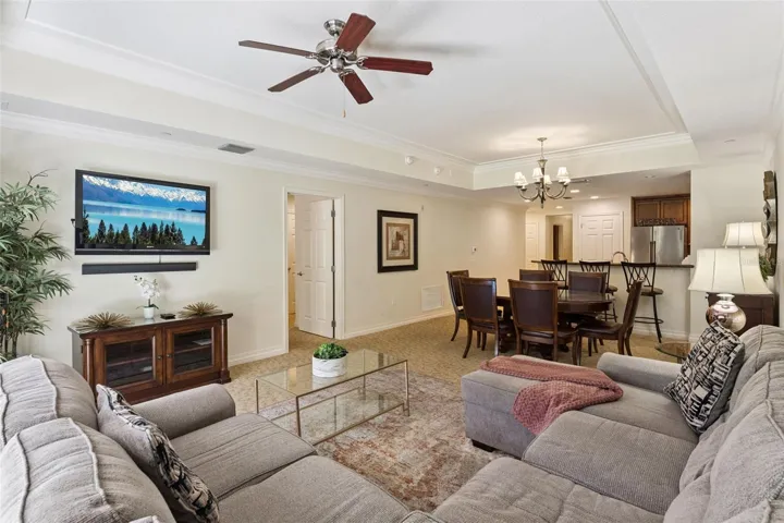 Open-Concept Layout: Spacious living and dining combination area seamlessly connecting to the kitchen, complete with tray ceiling accents and ceiling fans.