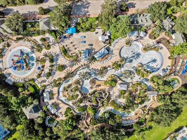 Overhead View of Water Park Complex: Complete top-down drone perspective of the expansive water park, featuring lazy river loops, splash zone, sunbathing decks, and cabanas.