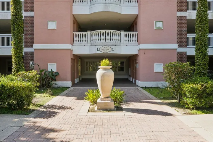 Building Entrance: Brick paver walkway and decorative urn planter leading into the covered building entrance.