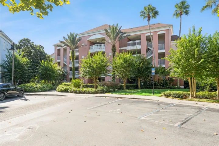 Parking &amp; Grounds: Convenient marked parking spaces steps from the building entrance with vibrant landscaping and palm tree accents.