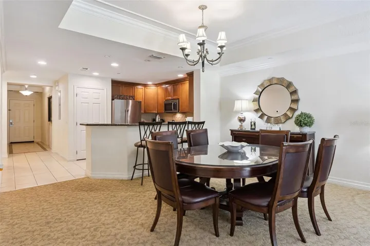 Dining Room &amp; Entryway: Dedicated dining area situated off the main foyer, complete with overhead chandelier lighting and adjacent access to the kitchen counter bar.