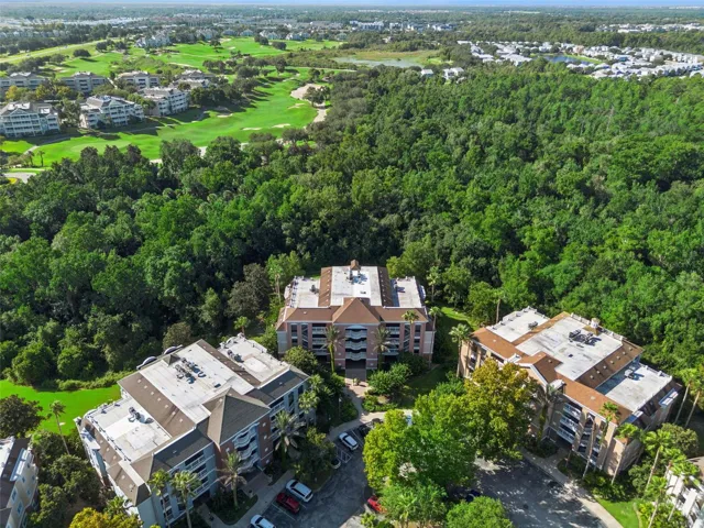 Overhead Conservation View: Overhead drone perspective highlighting the secluded setting of the residential buildings surrounded by dense tree canopy and neighboring golf greens.