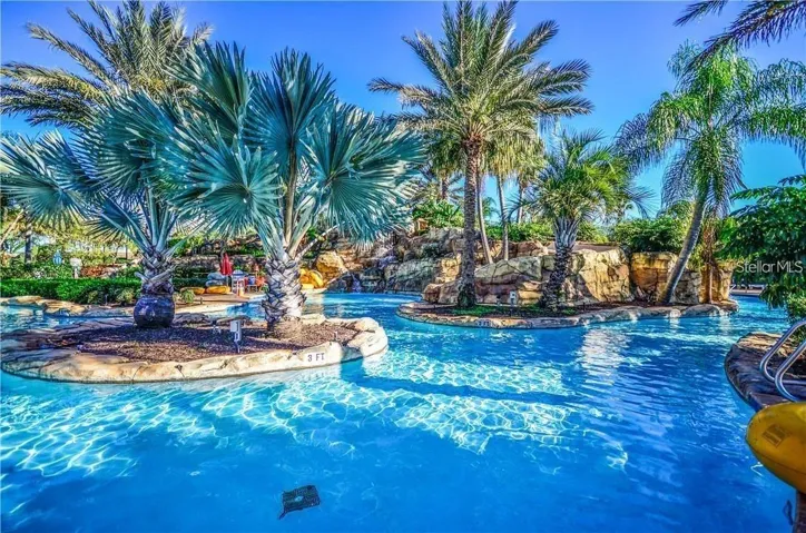 Tropical Lazy River &amp; Lagoon: Serene lazy river and lagoon pool winding past natural rock waterfalls and lush tropical palms.