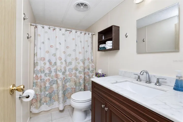Guest bath has an updated vanity w/solid surface countertop and updated toilet.
