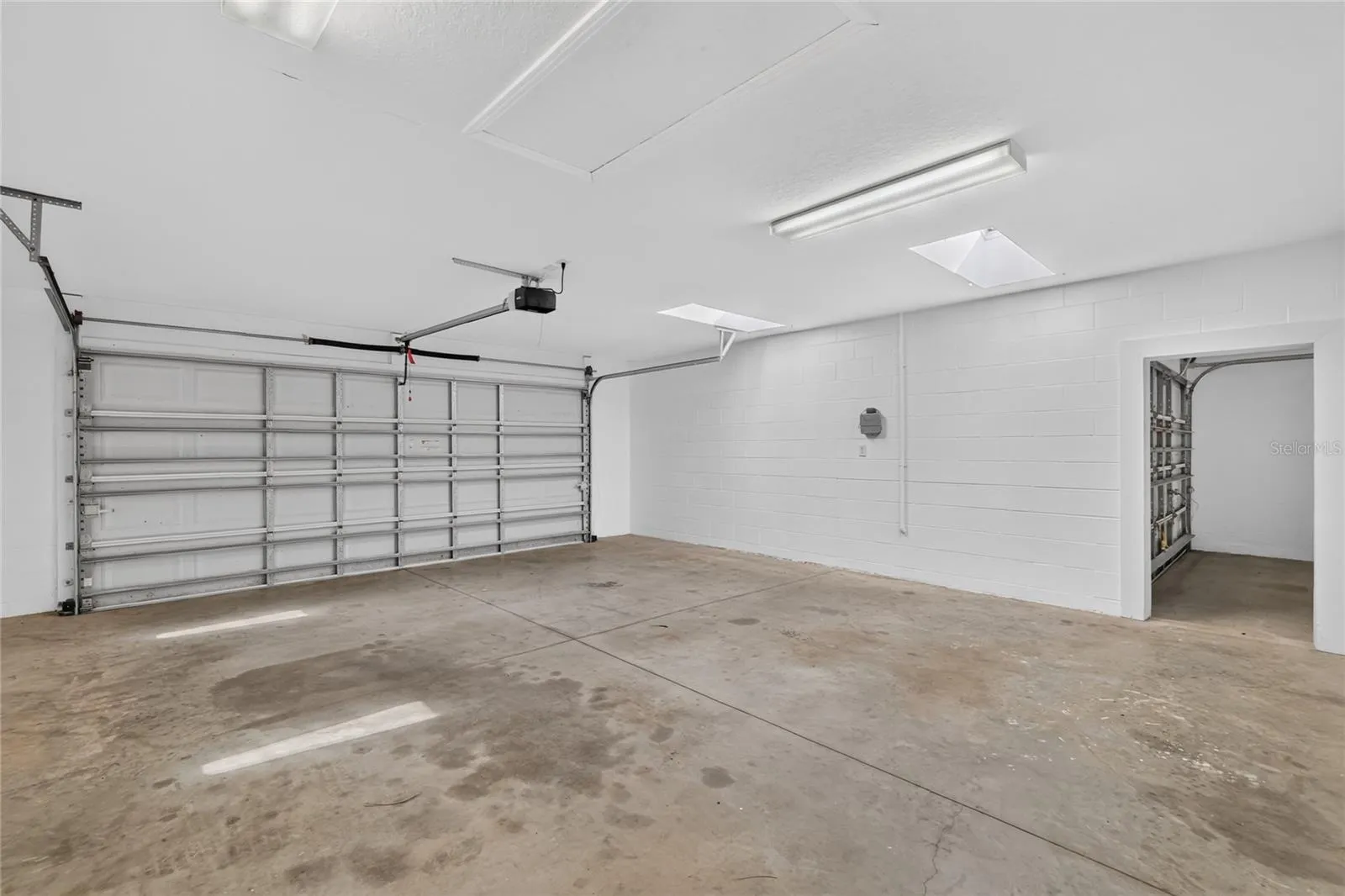 The additional garage features a workbench, storage shelving, and plenty of room for projects or recreational equipment.