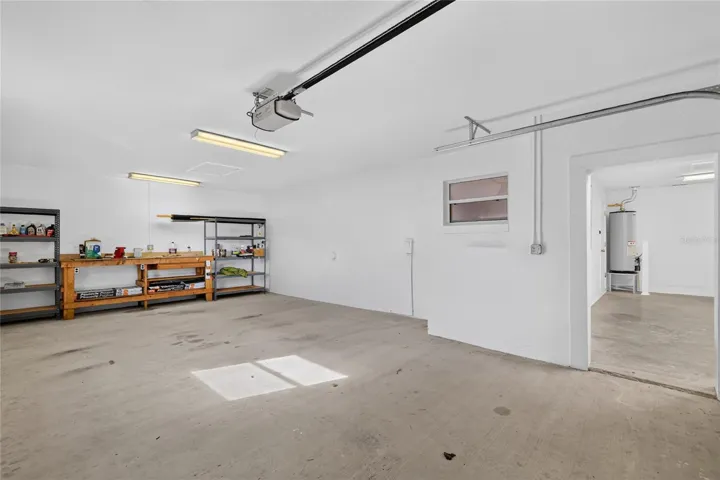 The additional garage features a workbench, storage shelving, and plenty of room for projects or recreational equipment.