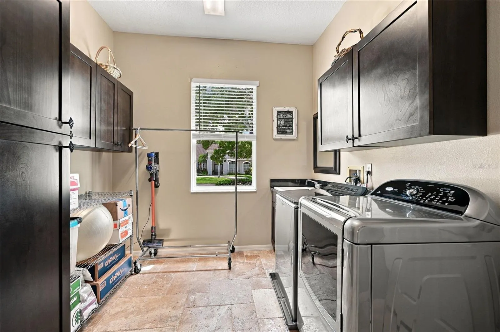 Primary Laundry with utility sink and storage cabinets